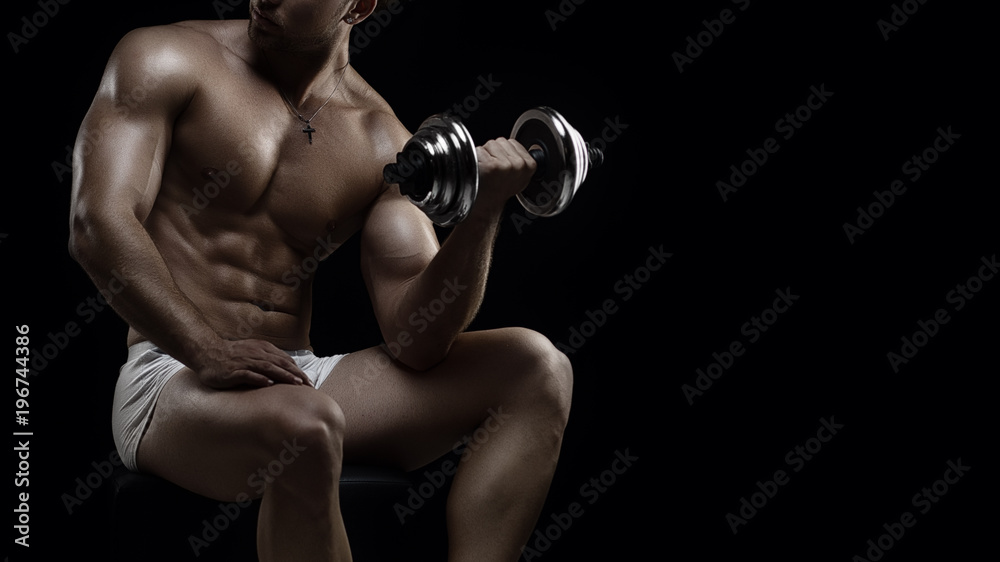 Young muscular man with dumbbell