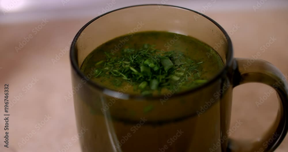 Cup of chicken broth with herbs Cup of chicken broth with herbs