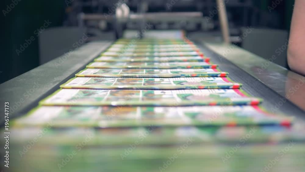 A part of journals coming out from a factory machine is getting collected 