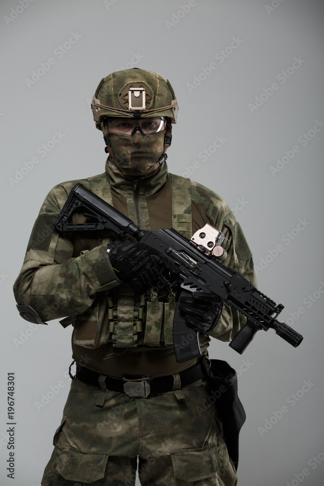 Fototapeta premium Photo of military man in camouflage with gun