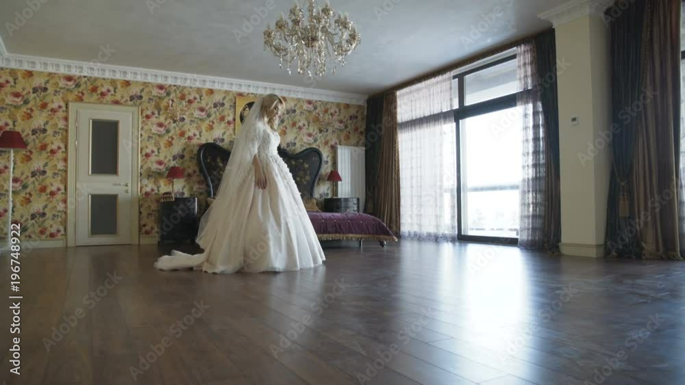 Gorgeous bride in dress walks in bedroom with smile. 4K