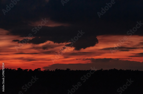 Sunset dramatic red sky with heavy dark blue rainy clouds