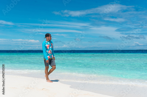 Man walking on beach with transparent water of ocean in Maldives © zulman
