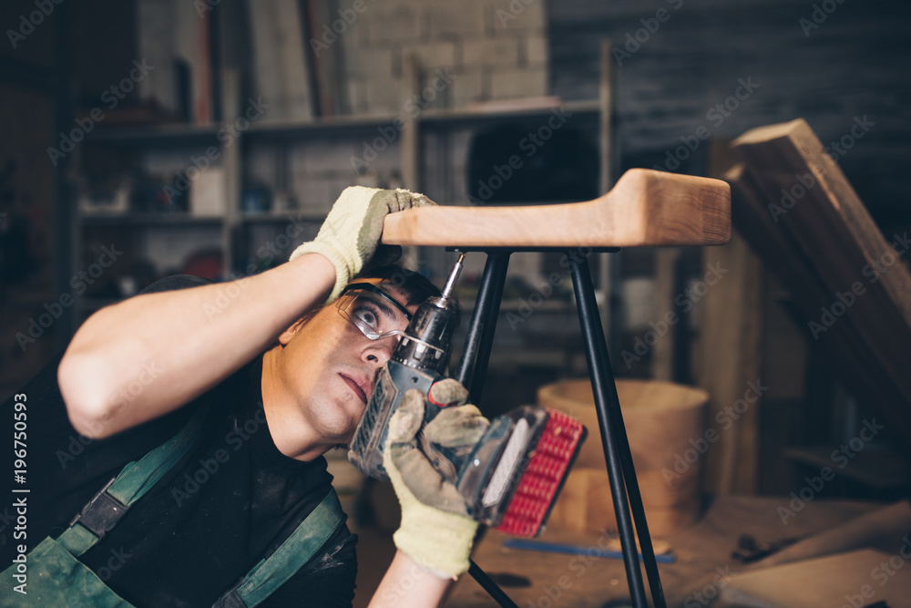 Naklejka premium Young master carpenter working in his woodwork or workshop.