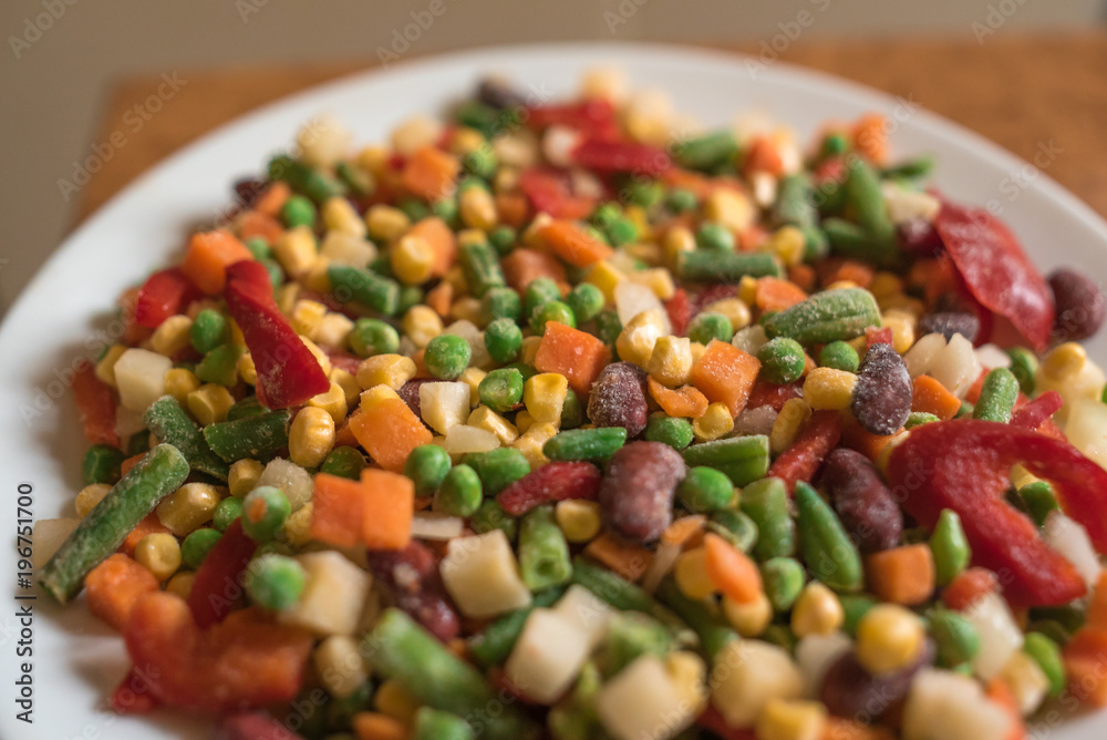 Frozen mexican mix of vegetables assorted on white plate Frozen mexican mix of vegetables assorted on white plate