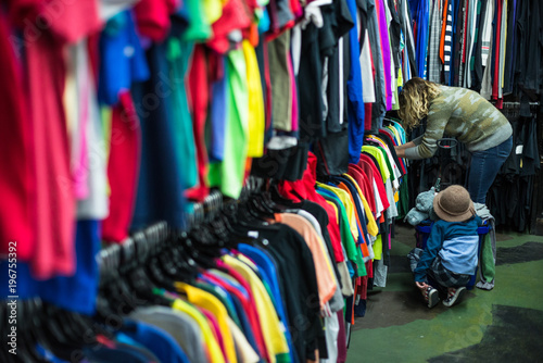 Woman and child browsing through clothing in a thrift store