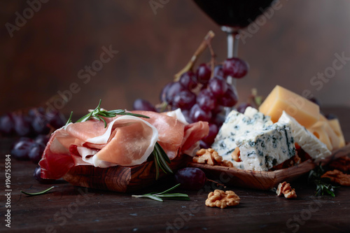 Prosciutto with various cheeses , grapes and walnuts .