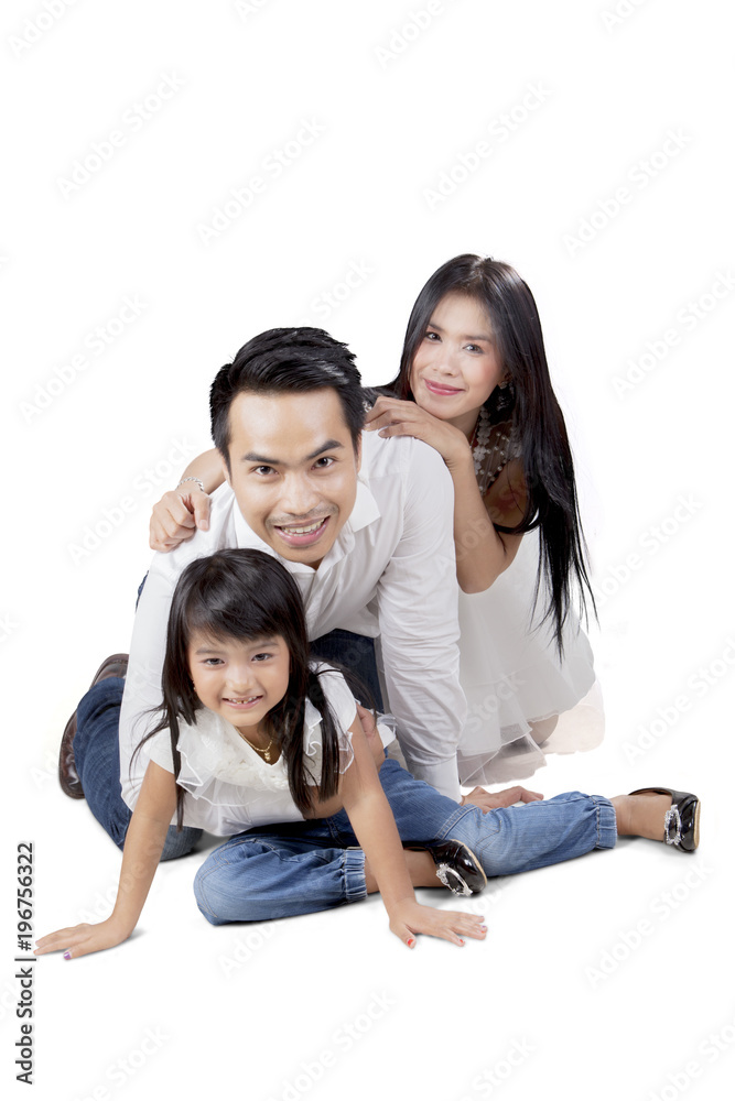 Young parents playing with their daughter on studio