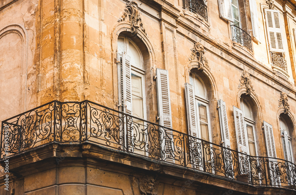 Fragment of old house in decay with forged balcony railings in Aix-en-Provence, France