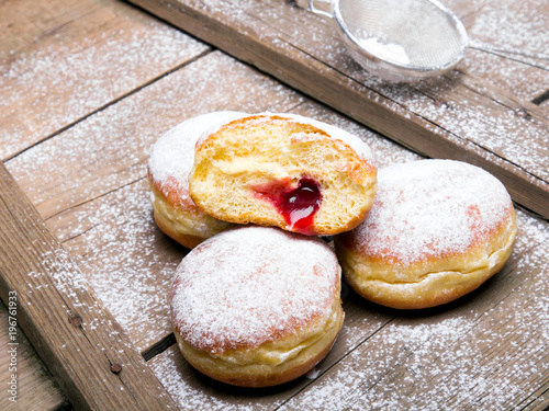 Traditional Polish donuts on wooden background. Tasty doughnuts with jam.