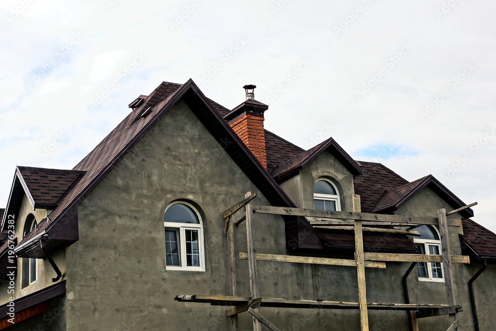 part of a gray new unfinished house against the sky part of a gray new unfinished house against the sky