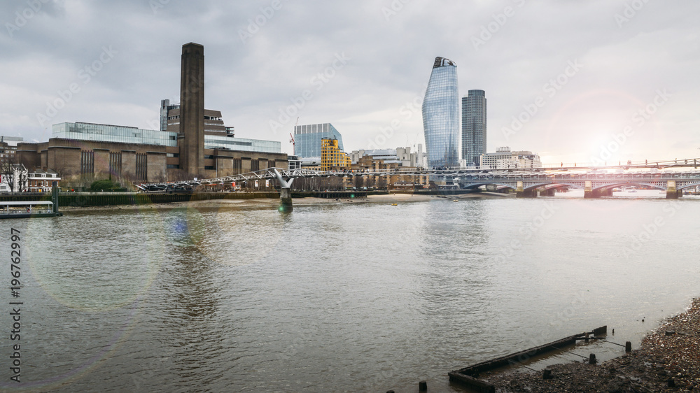 Naklejka premium View from the northern side of the Thames towards unidentifiable pedestrians crossing the Millennium Bridge leading to Tate Modern - London, England, UK.