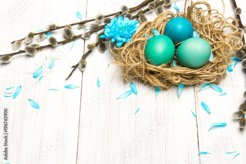 Easter background with eggs, nest and catkinson white wooden background, copy space
