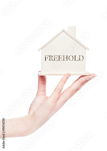 Female hand holding wooden house model with text