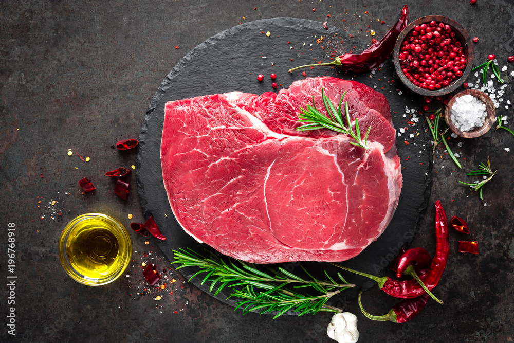 Raw beef steak on black background with cooking ingredients. Fresh beef meat. Top view