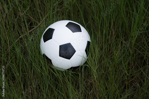 Top views of soccer ball on green grass of soccer field pattern background and texture. 