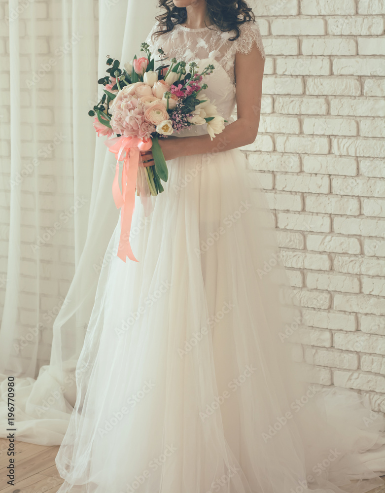 bride from a wedding bouquet near a white wall bride from a wedding bouquet near a white wall