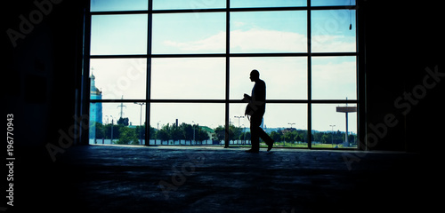 man walks against the window in the room.  Panoramic and web banner format.