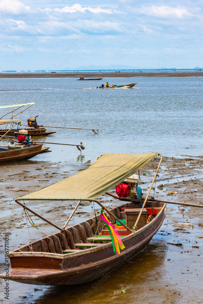 Wooden long tail boats on mud flats in the Maeklong River