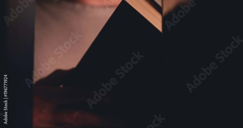 The man takes the book from the shelf and flips through it.
