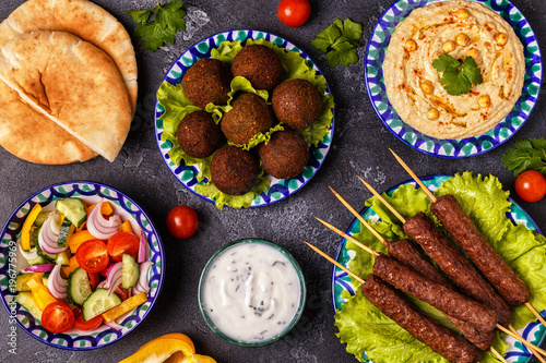 Classic kebabs, falafel and hummus on the plates. photo