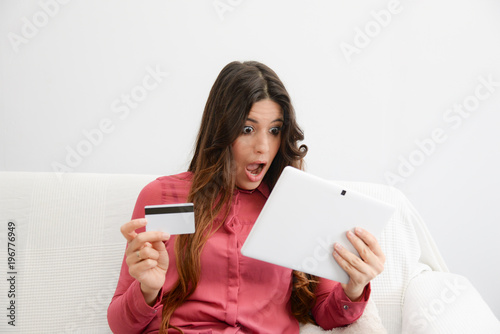 astonished woman buying offers online with credit card