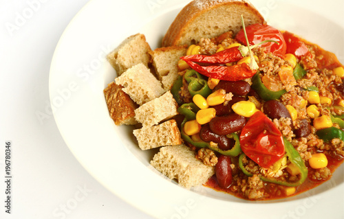 Chili con carne with Rye bread in white dish on white background