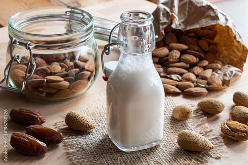 A bottle of almond milk with almonds and dates