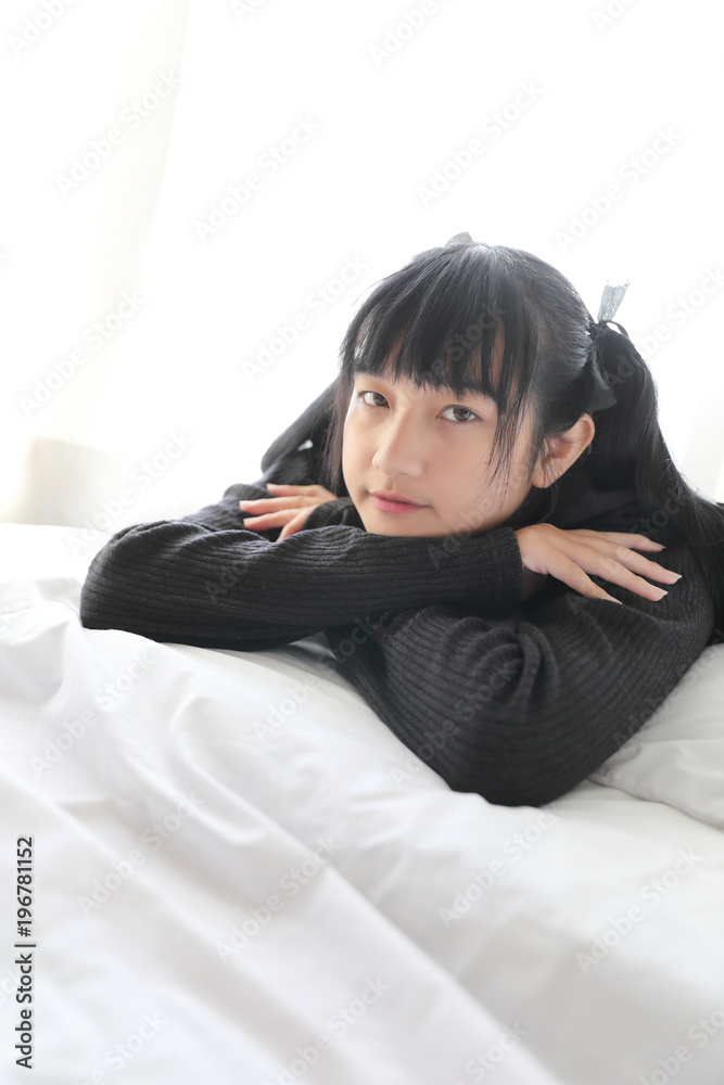 Young pretty girl wearing black cotton sweatshirt on bedroom white tone Young pretty girl wearing black cotton sweatshirt on bedroom white tone