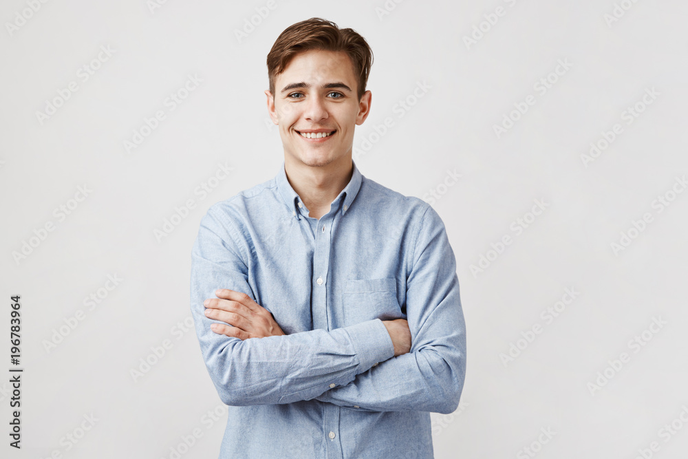 Portrait of handsome young man in casual blue shirt. Boy smiles for the camera expressing happiness and joy. His cute classmate finally agreed to go to prom with him. Friends will be jealous Portrait of handsome young man in casual blue shirt. Boy smiles for the camera expressing happiness and joy. His cute classmate finally agreed to go to prom with him. Friends will be jealous