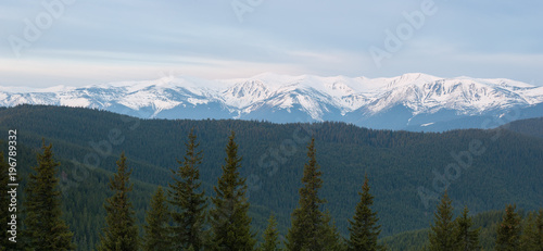 Spring landscape with a panorama of snowy mountains