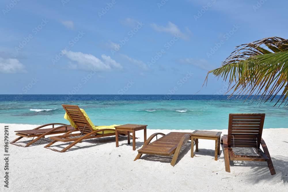 group of beach chairs on white sand