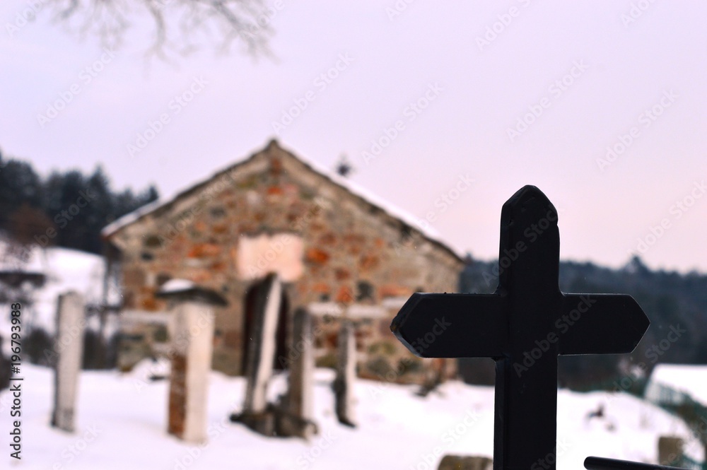 a stone church and a cross in the snow
a stone church and a cross in the snow