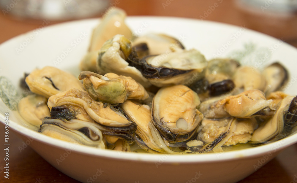 Tasty oiled pickled mussels iin a plate on the table Tasty oiled pickled mussels iin a plate on the table