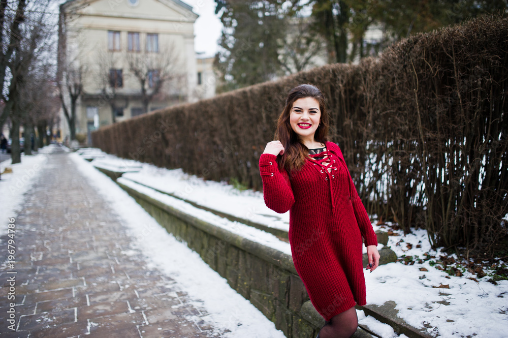 Brunette plus size model at red on street of city. Brunette plus size model at red on street of city.