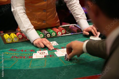 Dealer puts down a card on blackjack table photo