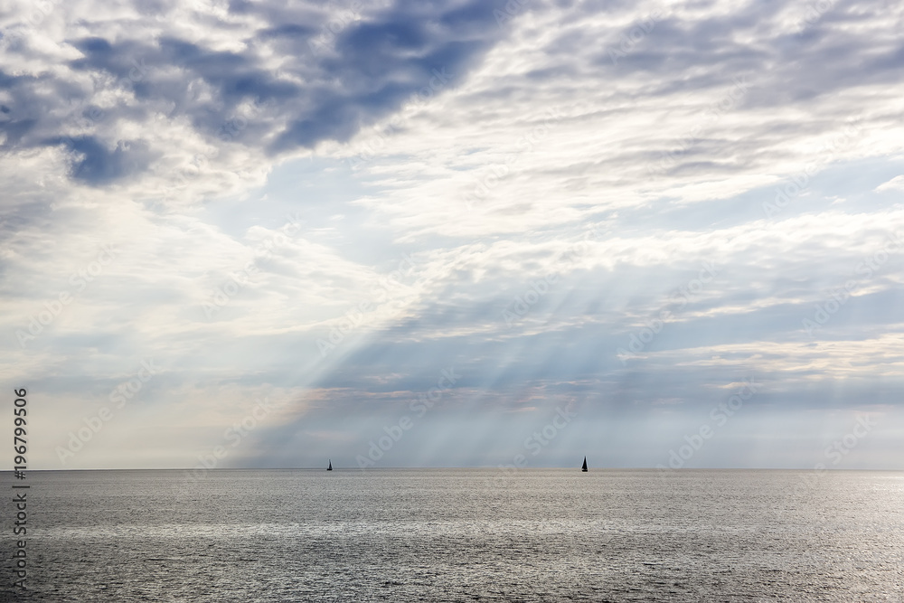 Sea landscape with a beautiful view of the clouds and beams of sun which are making way through a cloud Sea landscape with a beautiful view of the clouds and beams of sun which are making way through a cloud