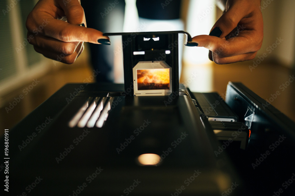 Woman's hands setup slide projector in the dark room Woman's hands setup slide projector in the dark room
