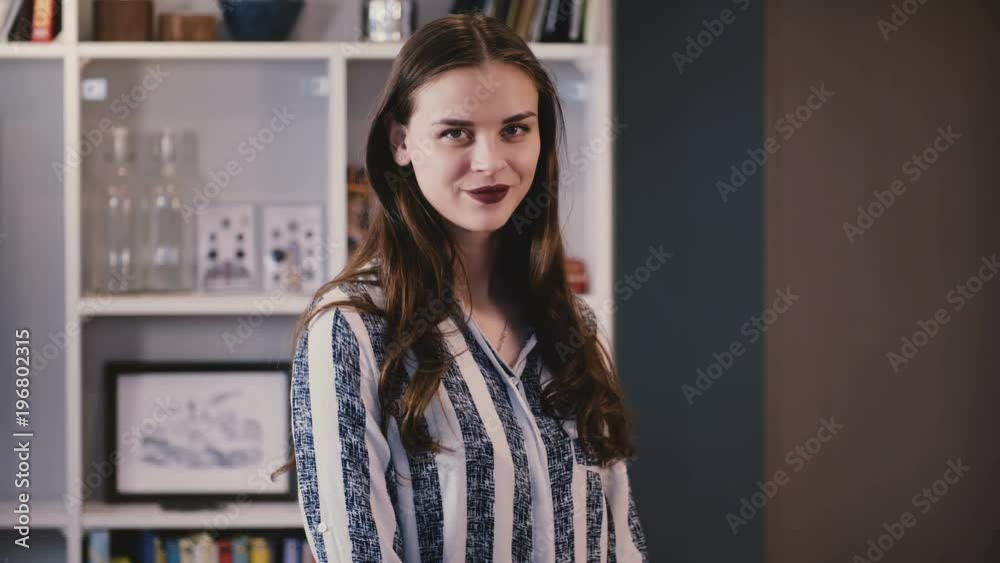 Portrait of cute Caucasian girl smiling at camera. Beautiful young businesswoman, long brown hair, dark lipstick. 4K. Portrait of cute Caucasian girl smiling at camera. Beautiful young businesswoman, long brown hair, dark lipstick. 4K.