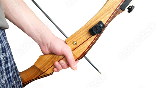 the male hand holds a handle of a recurve bow, a black arrow with a silver tip on a white background