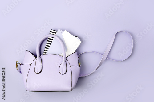 Cute blue handbag with , notebook and feminine accessories . Flat lay, top view. Spring fashion concept in pastel colored