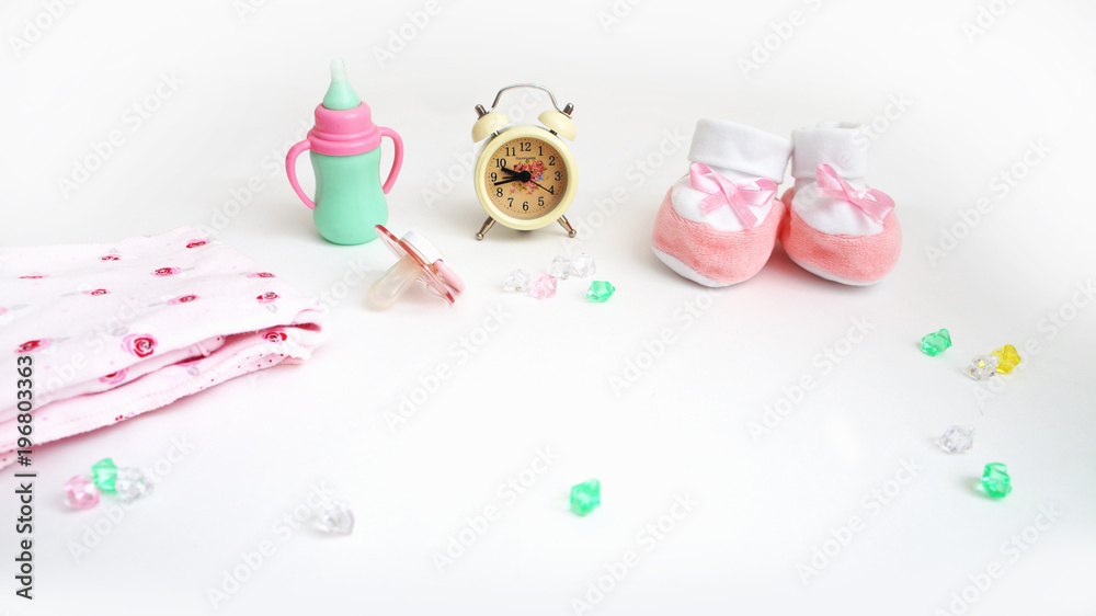 accessories for the child. the alarm clock, a small children's small bottle, a pacifier, bootees and a bed-sheet in krachny peas, multi-colored rhinestones. background, card accessories for the child. the alarm clock, a small children's small bottle, a pacifier, bootees and a bed-sheet in krachny peas, multi-colored rhinestones. background, card