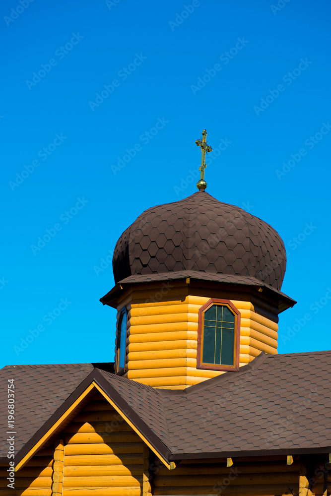 Domes of a wooden church on a blue sky background.