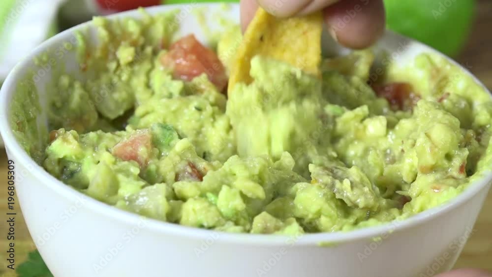 Scooping guacamole with a corn chip Scooping guacamole with a corn chip