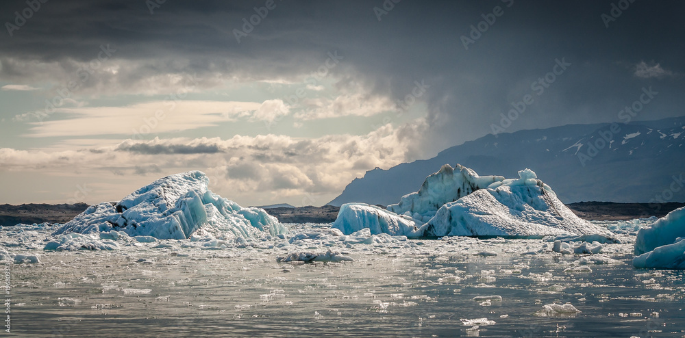 Icebergs on Jökulsárlón (Glacier River Lagoon) during a sunny day right before a storm in Iceland