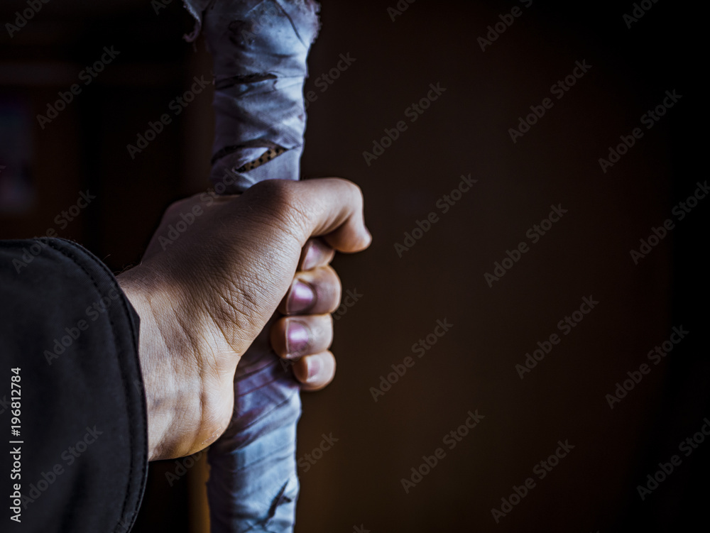 Fototapeta premium battle stick in the hand isolated black background