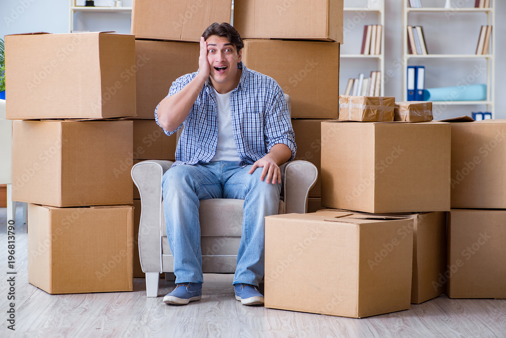 Young man moving in to new house with boxes Young man moving in to new house with boxes