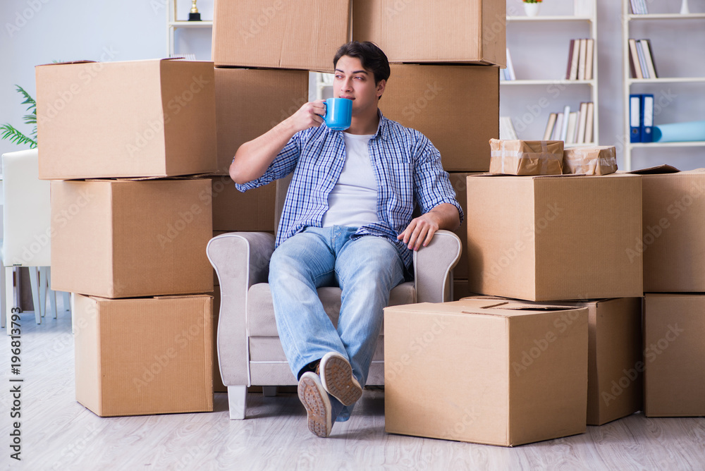 Young man moving in to new house with boxes Young man moving in to new house with boxes