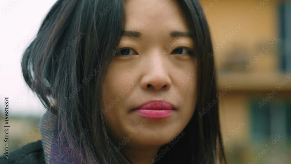 close up on attractive young chinese woman looking in camera- outdoor close up on attractive young chinese woman looking in camera- outdoor
