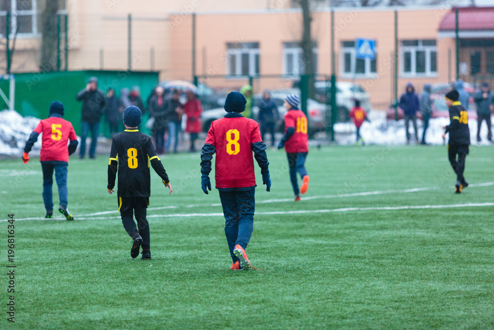 Fototapeta premium boys play football on the winter stadium